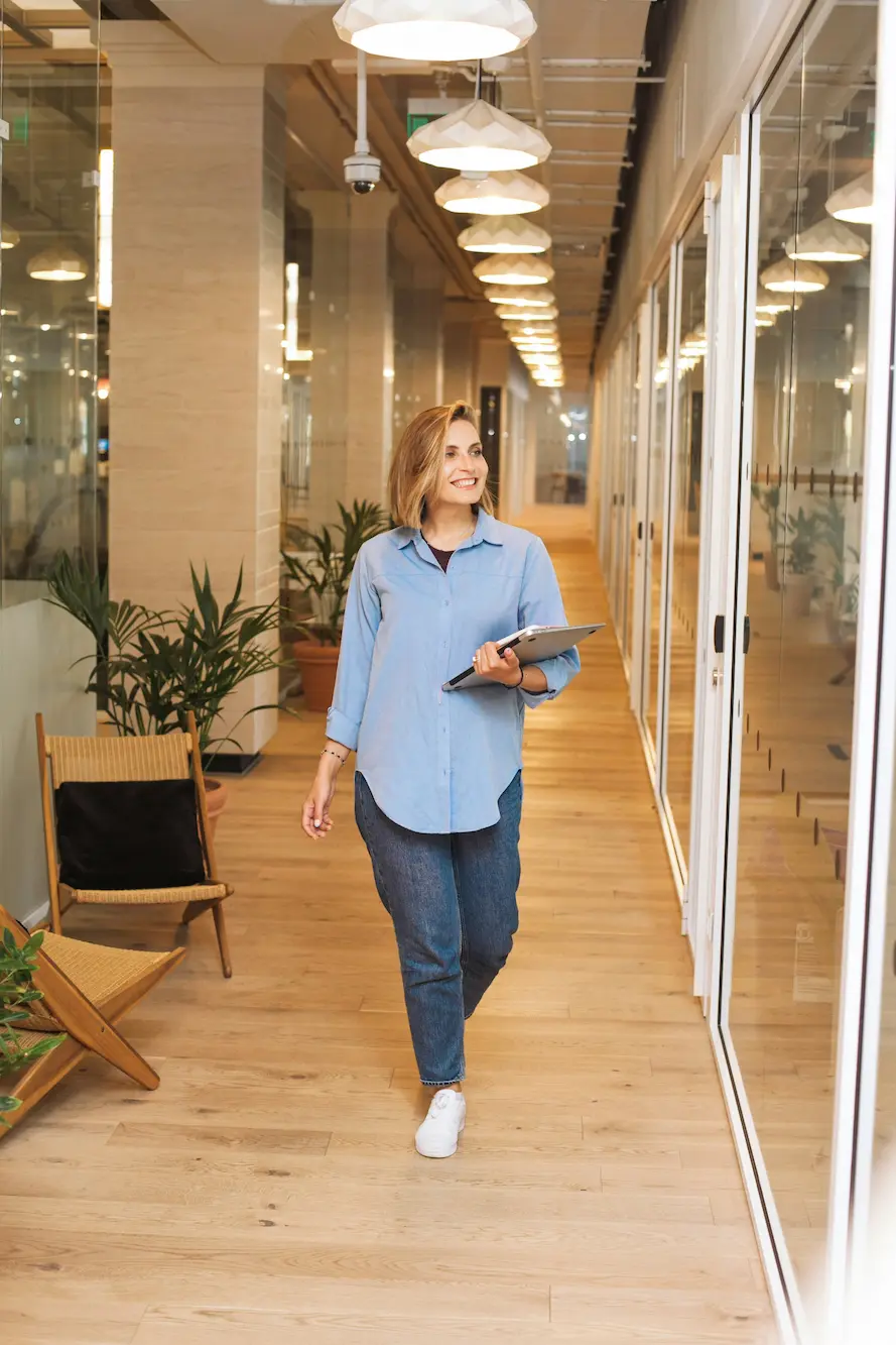 Femme marchant dans un bureau avec un ordinateur